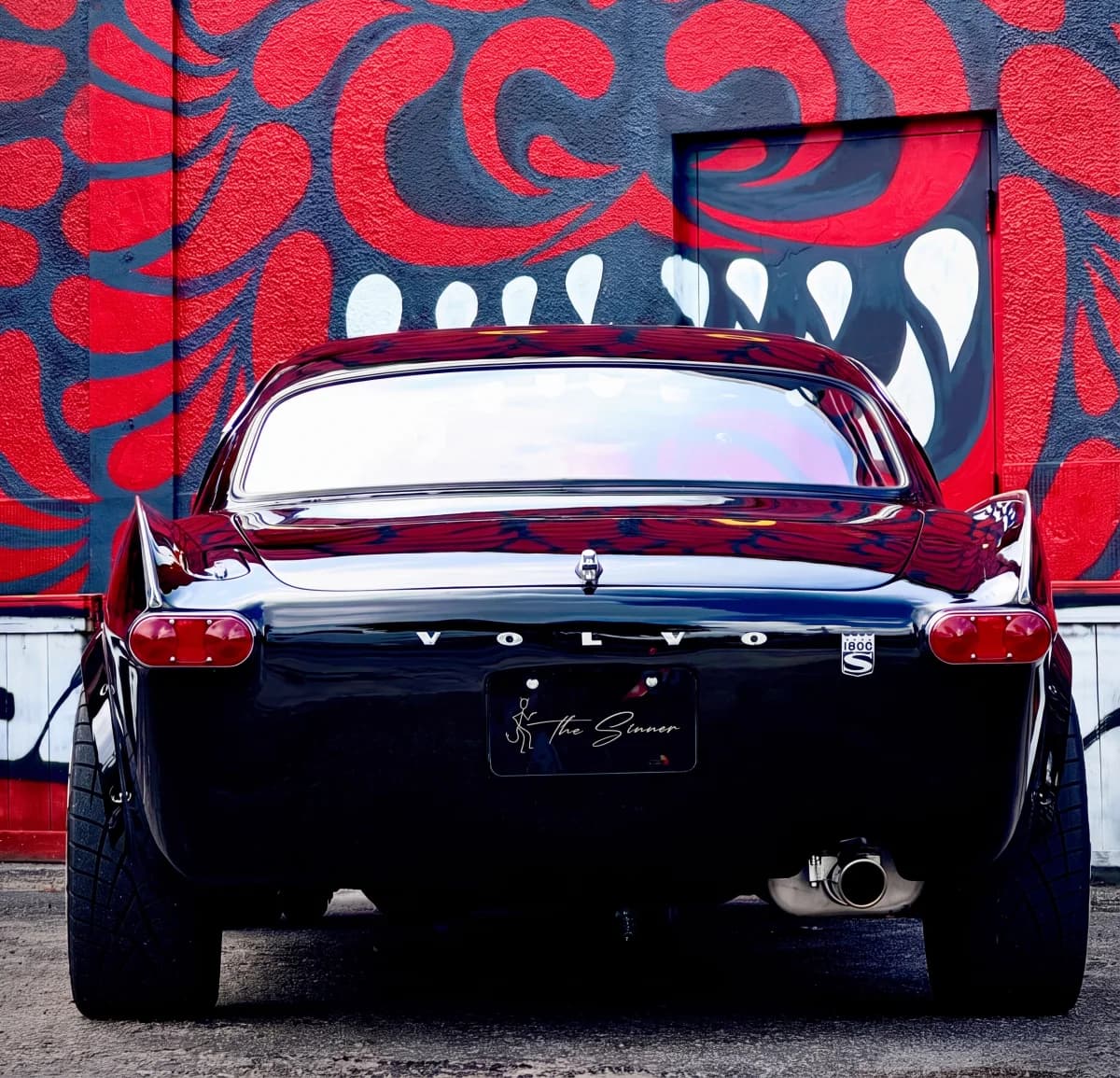 The Sinner, Ken Russell's 1965 Volvo 1800S, photographed from behind against a red painted mural